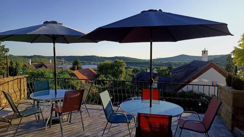 two tables and chairs with umbrellas on a patio at T.H.NY Village Inn Cottage in Tihany