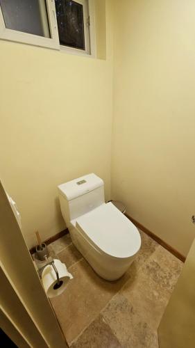 a white toilet in a bathroom with a window at Dreamcatcher Luxury in Santa Teresa Beach