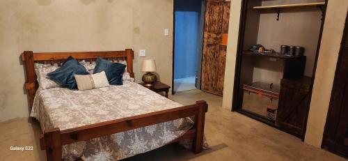 a bedroom with a bed with blue pillows at Boemsies in Jacobsdal