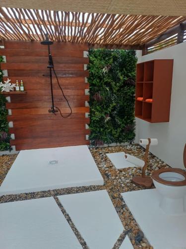 a bathroom with a toilet and a wooden wall at Gaïa Beach and Lagoon Moorea in Haapiti