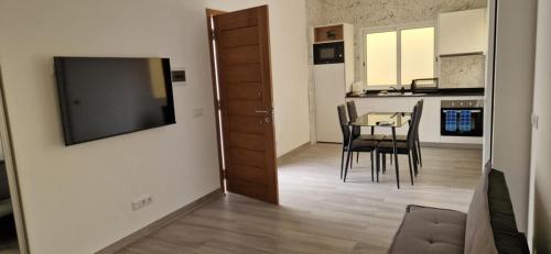 a living room with a table and a television on a wall at Ines Studio T0 - Inforsal in Espargos