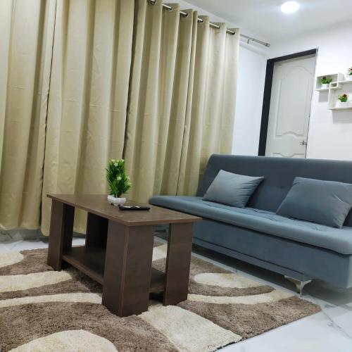 a living room with a blue couch and a table at 1BHK #401 Feel At Home Netflix & High Speed Net Self Service Apartment in Chinchiwad
