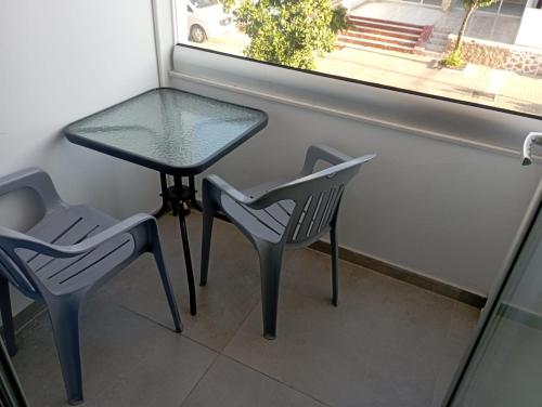 a table and two chairs and a table and a window at Golden Sun Rooms - Adults Only in Ayia Napa
