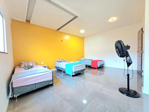 a room with two beds and a fan in it at Casa Altos COP30, Next to the Hangar in Belém