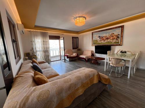 a living room with a couch and a dining room at Vila Behar - Penthouse Apartment with seaview in Sarandë