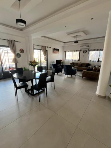 a large living room with a table and chairs at Chez Léa Mariame in Malikounda