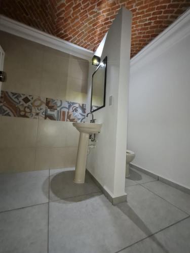 a bathroom with a sink and a mirror and a toilet at La Finca Tilhuacán in San Lucas Xoloc