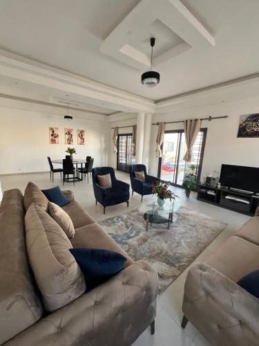 a large living room with a couch and chairs at Chez Léa Mariame in Malikounda