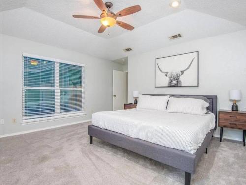 a bedroom with a bed and a ceiling fan at Family Haven Pool, Game Room, Near Cowboys Hq in Plano