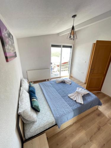 a bedroom with a bed with blue sheets and a window at Villa 80 Kodra e Diellit in Tetovo