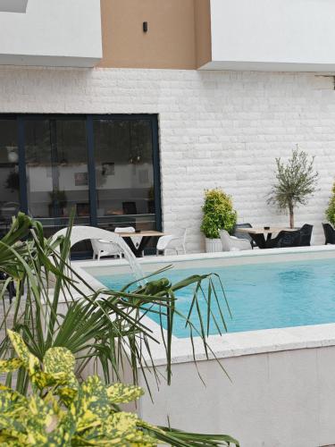 a swimming pool in a building with chairs and tables at POOL RESORT Vila Lena - Lux residence apartman 1 in Vrdnik