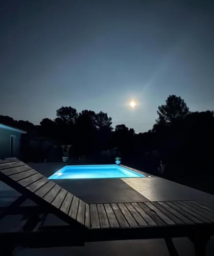 a swimming pool at night with a bench next to it at Villa avec piscine, en Provence in Varages