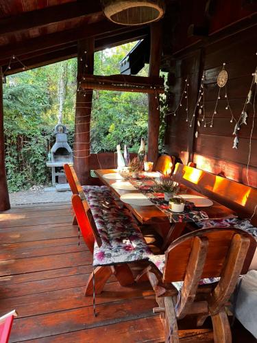 ein Esszimmer mit einem langen Tisch auf einer Terrasse in der Unterkunft Domek Nowy Lubiel in Lubiel Stary