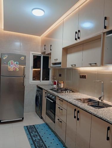 a kitchen with a stainless steel refrigerator and a dishwasher at Airport view apartment Marrakech in Marrakech