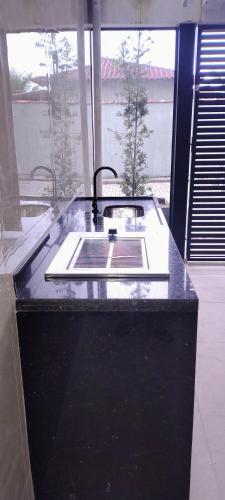 a kitchen counter with a sink in a room at Condominio Nova angra in Angra dos Reis