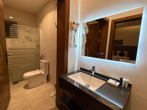 a bathroom with a sink and a toilet and a mirror at شقق سوار الذهب للشقق المخدومة in Sīdī Ḩamzah