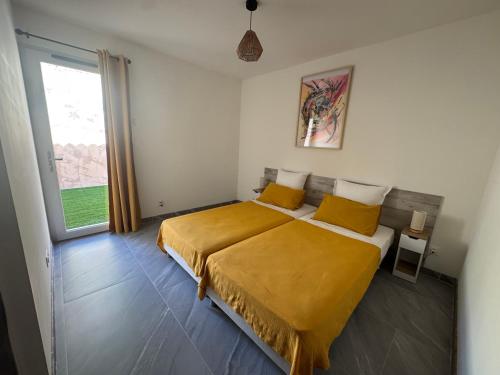 a bedroom with a bed with yellow sheets and a window at Villa avec piscine, en Provence in Varages