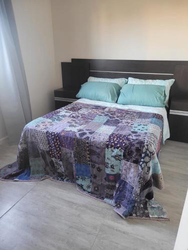 a bed with a quilt on it in a room at Abrilalquilertemporario in Piñero