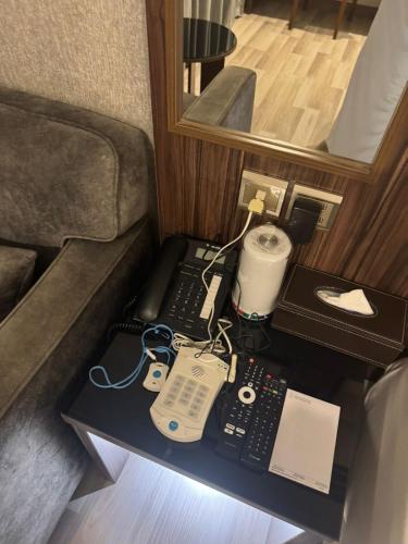 a table with a phone and other electronics on it at White Diamond Hotel Sari in Jeddah