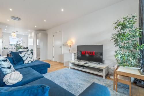 a living room with blue couches and a tv at Luxury 3BR with 2bath Near Westfield Stratford in London