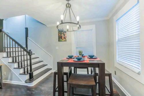 a dining room with a wooden table and chairs and a chandelier at 2 Kitchenssleeps 105 Car Parking in Atlanta