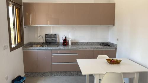 a kitchen with a counter and a white table at Appartement avec jardin route Saïdia in Berkawe