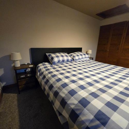 a bedroom with a bed with a blue and white checkered blanket at Swallow cottage in Howden