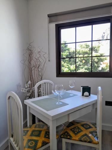 a white table and chairs with wine glasses on it at Casa Ascensión del Mar in San Andrés