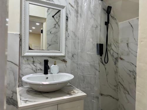 a bathroom with a white sink and a mirror at Oceanview Suites in Saint Georgeʼs