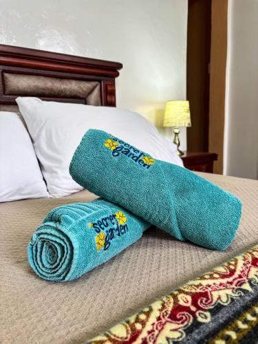 a pair of towels sitting on top of a bed at The Secret Garden in Quito