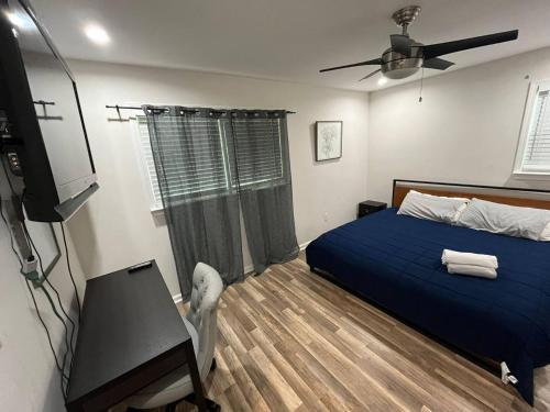 a bedroom with a blue bed and a ceiling fan at 2 mins walk to Benz stadiumArcade game Sleeps 11 in Atlanta