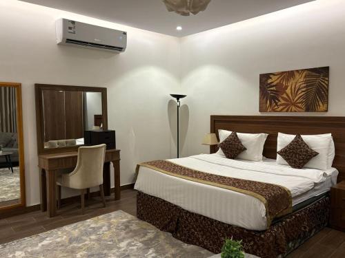 a bedroom with a bed and a desk with a computer at شقق سوار الذهب للشقق المخدومة in Sīdī Ḩamzah