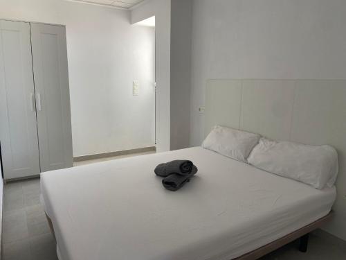 a hat sitting on top of a white bed at Villatella in Burriana