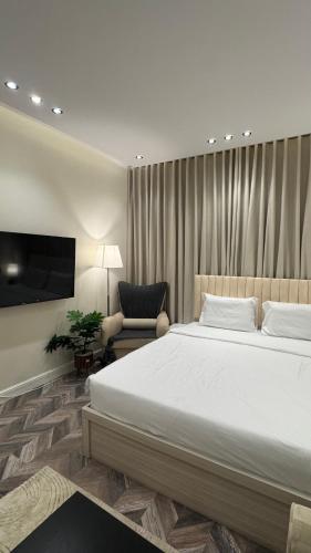 a bedroom with a large white bed and a chair at شقة حي الوزارات in Riyadh