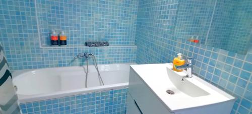 a blue tiled bathroom with a sink and a tub at Thalassa View c3 in Khalkoútsion