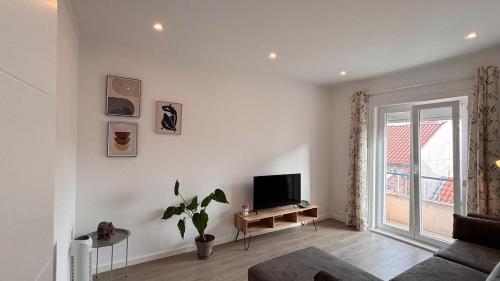a living room with a couch and a television at Charming Baixa VI - 2 Room Apt in Lavradio
