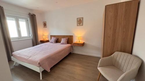 Un dormitorio con una cama y una silla y una ventana. en Charming Baixa VI - 2 Room Apt, en Lavradio