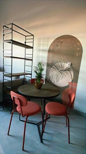 a table and two chairs with a plant on it at Nowe Młyny apartament 59 in Leszno