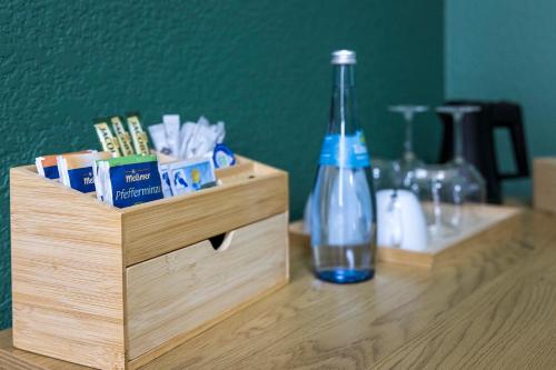 a wooden box with a bottle on a table at Hotel Residenz Luxury - Outletcity - Parken - Klima - 24h Check-In in Metzingen