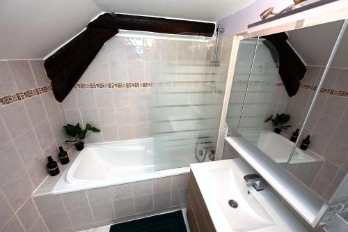 a bathroom with a bath tub and a sink at Ecrin calme à Nancy - A deux pas de la place Stanislas Appart 2ch in Nancy