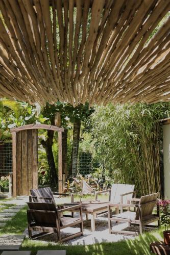 a patio with chairs and a wooden pergola at Soul Trancoso - Hotel Boutique in Trancoso