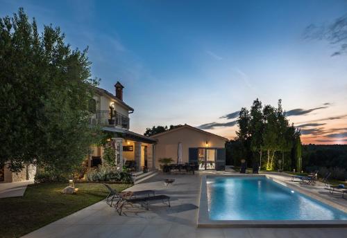 a backyard with a swimming pool and a house at Villa PERLA VERDE in Labin