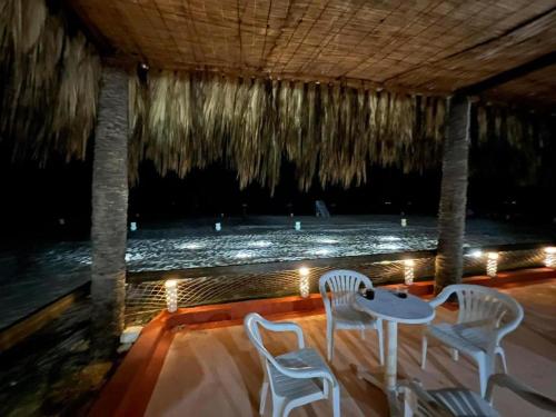 a patio with a table and chairs and the ocean at Caribiano villa-3 in Dawwār Ḩalīs