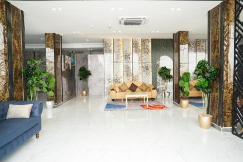 a living room with a blue couch and plants at hotel rose garden فندق روز جاردن in Duqm