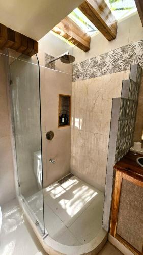 a bathroom with a glass shower with a toilet at Dreamcatcher Luxury in Santa Teresa Beach
