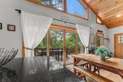 a dining room with a table and some windows at Mins To Highlands Hot Tub, Fire Pit, Game Room in Franklin