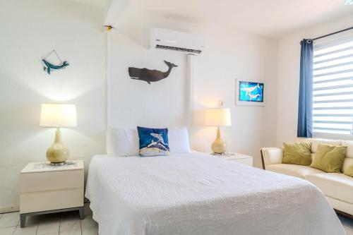 a white bedroom with a bed and a couch at Coconut Palms Inn in Rincon