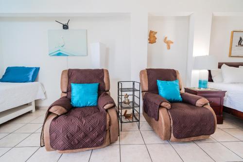 two chairs sitting in a room with a bed at Coconut Palms Inn in Rincon