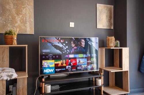 a flat screen tv sitting on a stand in a living room at 3Bed House in Hatfield in Hatfield