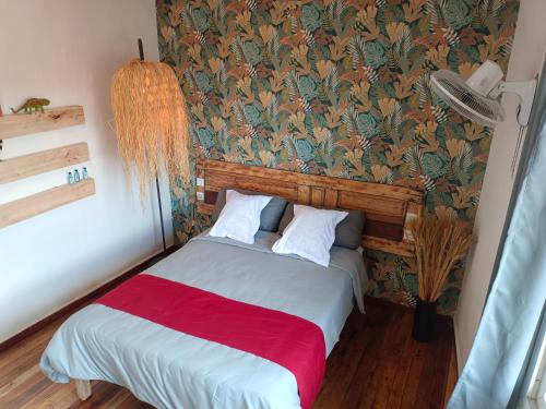 a bedroom with a bed with a red blanket at Le Réverbère in Antananarivo